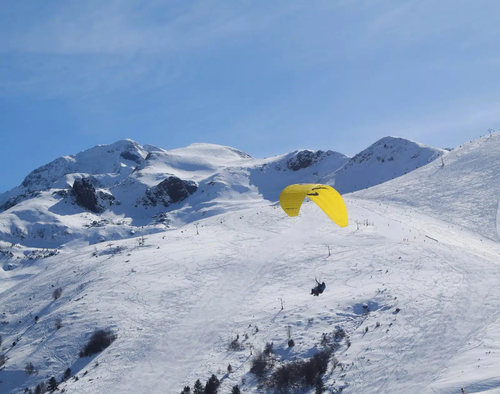 Vol parapente en biplace au-dessus des pistes enneigées